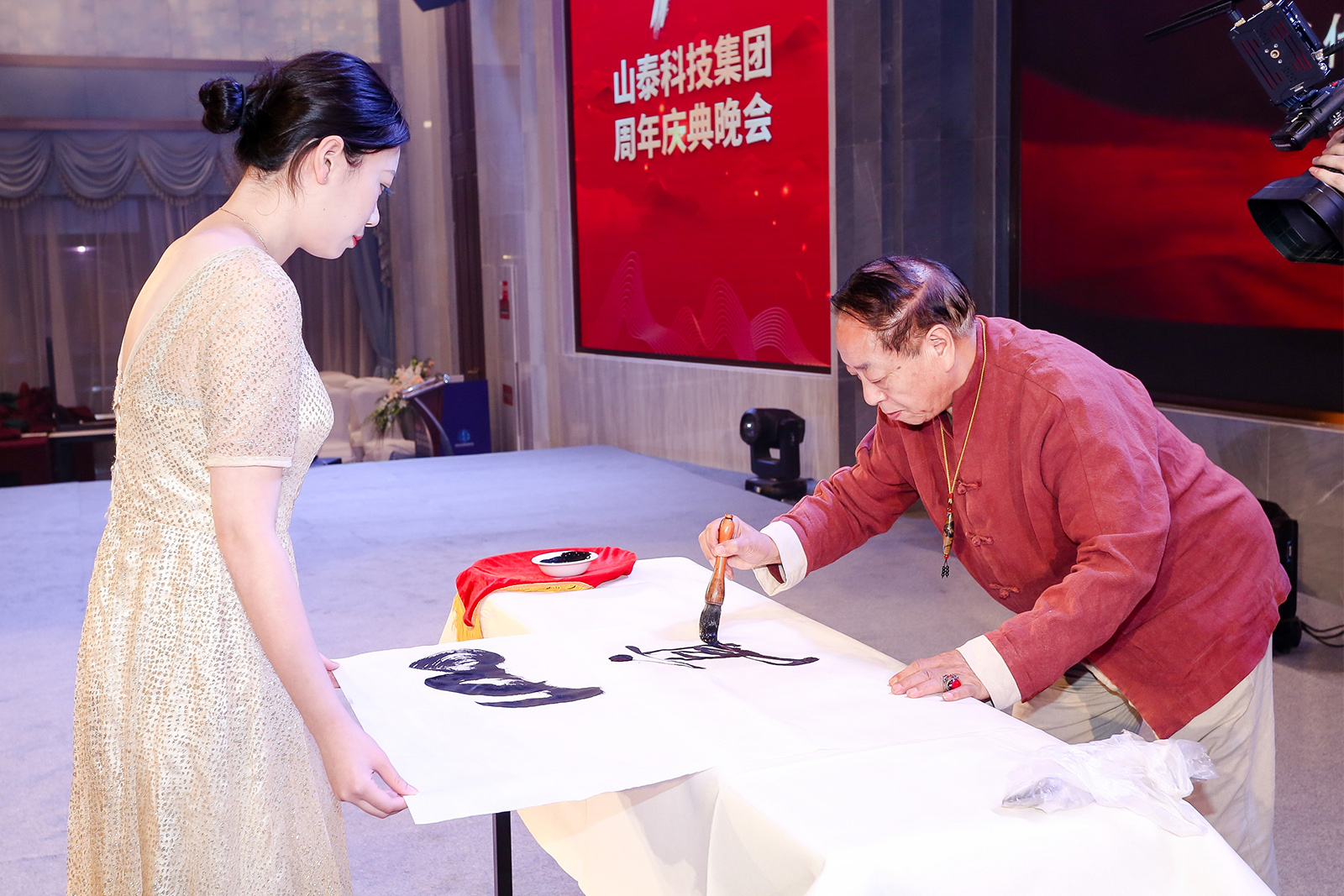 書畫名家程俊良在山泰十周年慶典晚會現(xiàn)場書寫“山高人為峰”